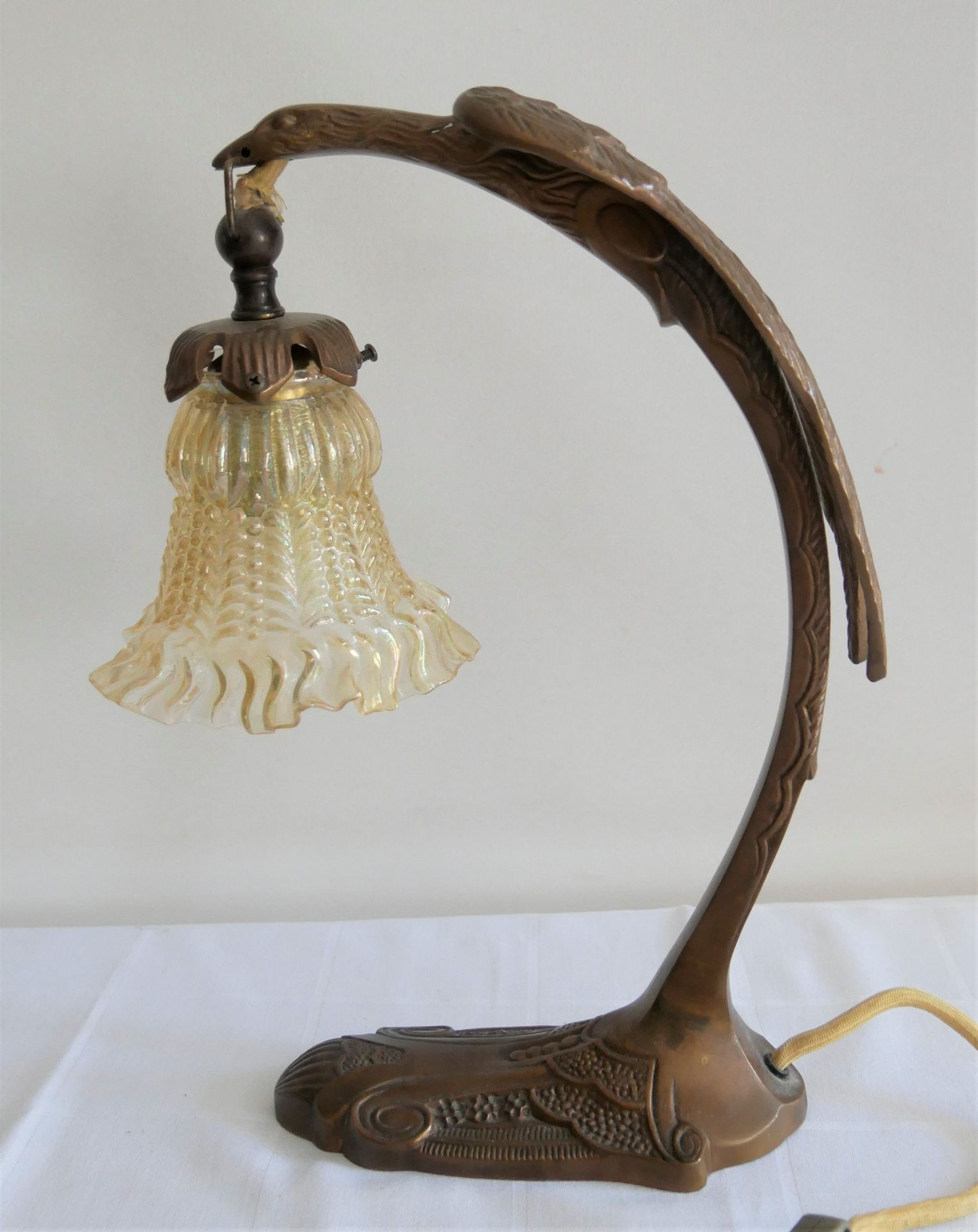 Art Deco Tischlampe in Form eines stilisierten Vogels mit einem Glaslampenschirm. Höhe ca. 34 cm