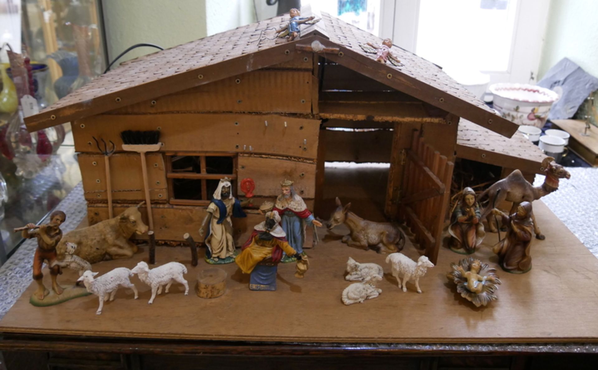 große Holzkrippe mit Beleuchtung. Dabei 17 Krippenfiguren, Josef, Maria, Jesuskind, Schafe, etc.