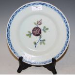 AN 18TH/ 19TH CENTURY DELFT POTTERY PLATE WITH GREEN AND MANGANESE COPPER DECORATION OF A FOLIATE