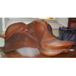 A LEATHER SADDLE BY SCHRODER, TOGETHER WITH A BAG CONTAINING TWO STIRRUPS AND PARTS OF REIGNS/