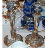 A PAIR OF SHEFFIELD PLATE CANDLESTICKS WITH EMBOSSED FOLIATE DETAIL