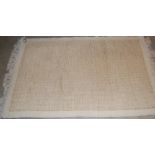 A MODERN OFF-WHITE AND SAND COLOURED WOOL RUG, TOGETHER WITH A SMALL BLUE GROUND PRAYER MAT