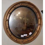 A LATE 19TH/ EARLY 20TH CENTURY GILT FRAMED CIRCULAR CONVEX WALL MIRROR IN THE REGENCY STYLE