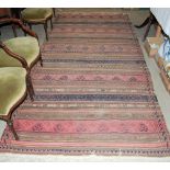 A WOVEN PERSIAN RUG, WORKED IN BLUE, MADDER, BROWN AND OFF-WHITE COLOURED THREADS, APPROX. 350CM X