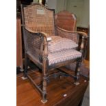 A STAINED BEECH SIDE CHAIR WITH CANEWORK BACK, ARMS AND UPHOLSTERED SEAT