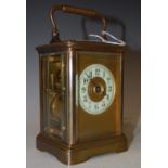 AN EARLY 20TH CENTURY CARRIAGE CLOCK, THE CIRCULAR DIAL WITH ARABIC NUMERALS, THE TWIN TRAIN