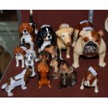 A GROUP OF ELEVEN ASSORTED CERAMIC DOG FIGURES TO INCLUDE EXAMPLES BY BESWICK AND OTHER FACTORIES