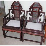 A PAIR OF CHINESE DARK WOOD ARMCHAIRS, THE BACKS CARVED AND PIERCED WITH FIGURES, FLOWERS AND