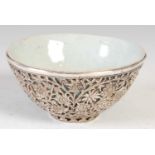 A Chinese porcelain celadon glazed bowl, Qing Dynasty, in white metal pierced and foliate embossed