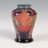 Pomegranate, a miniature Moorcroft vase, decorated with stylised fruit and foliage on a blue/
