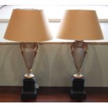 A pair of decorative painted metal three light table lamps and shades, formed from a pair of off-