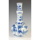 A Chinese porcelain blue and white bottle vase, Qing Dynasty, decorated with figures in a fenced