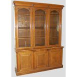 A 19th century oak bookcase, the moulded cornice with four stylised floral bosses above three arched