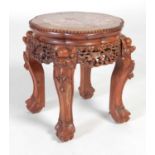 A Chinese dark wood urn stand, Qing Dynasty, the shaped circular top with mottled purple and white