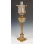 A late 19th/ early 20th century brass Corinthian column oil lamp, the clear and frosted glass