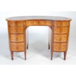 A late 19th/ early 20th century satinwood and marquetry inlaid kidney-shaped desk, the shaped top