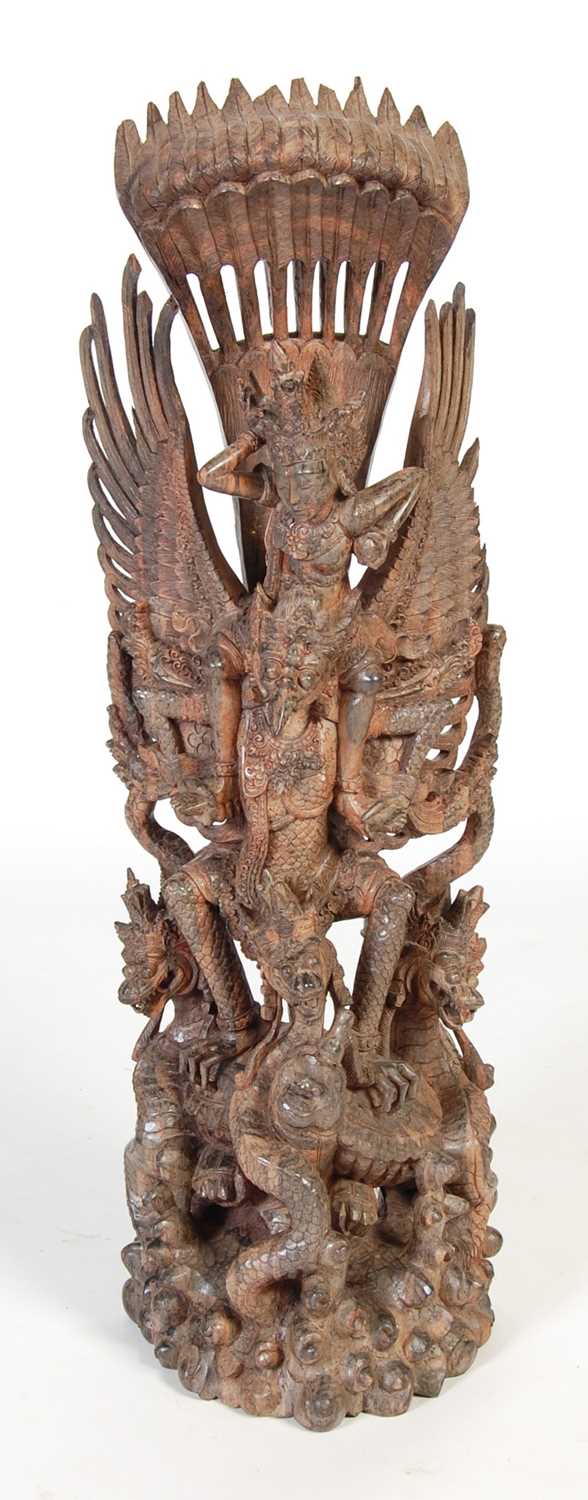 An Indonesian carved hardwood figure of Garuda and dragons, 97.5cm high.