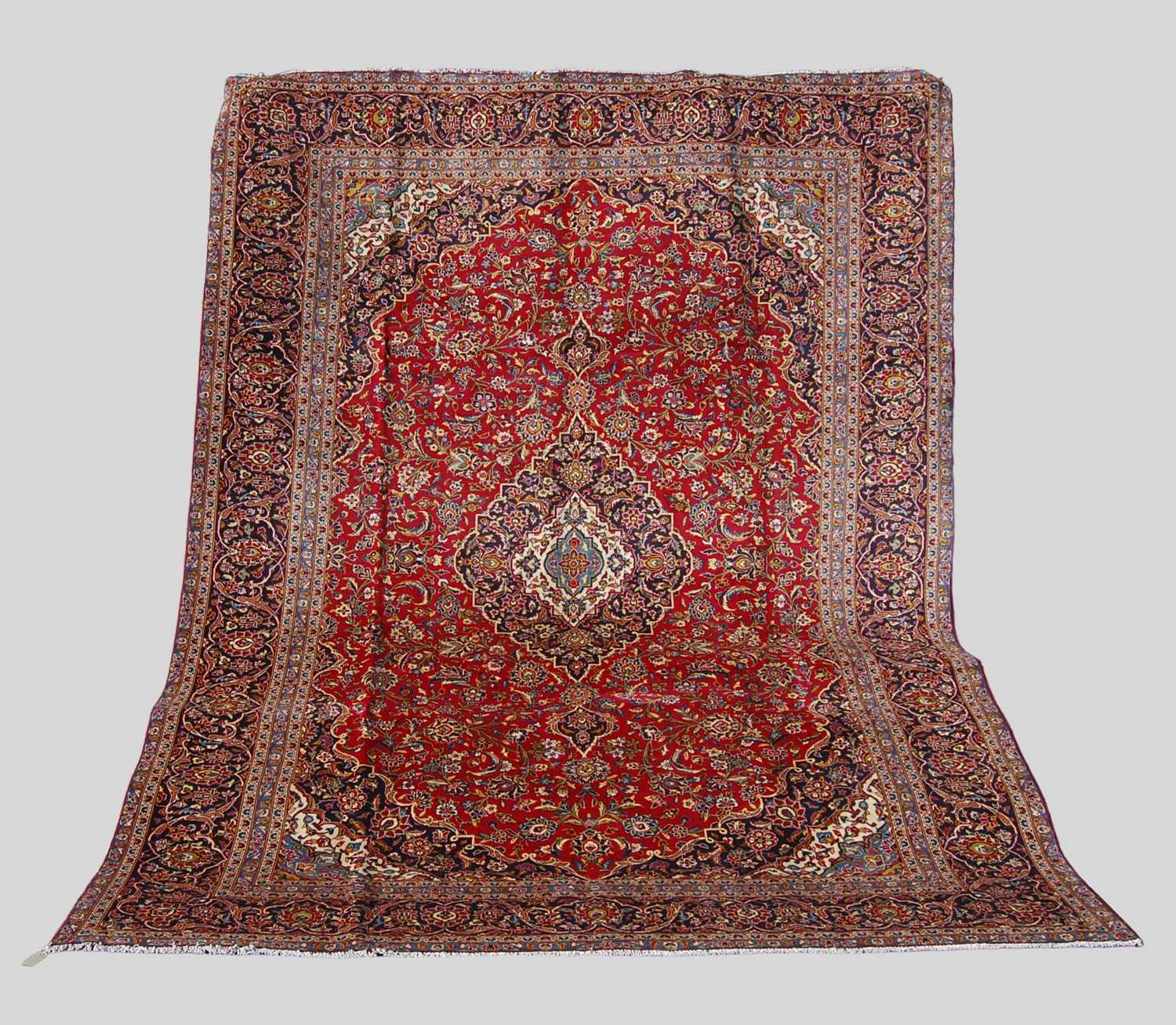 A Persian Kashan carpet, the rectangular field centred with a blue ground oval medallion within a