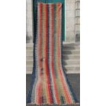 A blue ground kelim runner, decorated with rows of off-white, madder, ochre and green teeth shaped