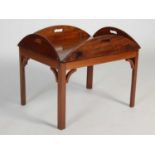 A 19th century mahogany butlers tray mounted as a table on later integral mahogany stand, the oval