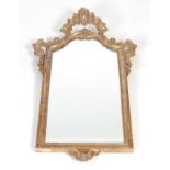 A George III style giltwood wall mirror, the rectangular mirror plate within scroll carved border,