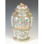 A Chinese porcelain famille rose Canton temple jar and cover, Qing Dynasty, decorated with panels of