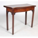 A George III mahogany serpentine card table, the shaped top with moulded edge opening to a green