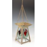 An Arts & Crafts brass and leaded glass hall lantern, decorated with four red stylised tulips with