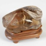 A Chinese rock crystal carving of a Shishi dog, late 19th/ early 20th century, on carved wooden
