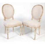 A pair of painted beech wood side chairs, the oval backs and serpentine seats upholstered with