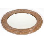 An early 20th century Arts & Crafts copper wall mirror, the oval mirror plate within an embossed