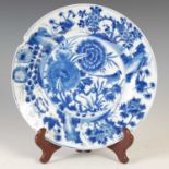 A Chinese porcelain blue and white plate, Qing Dynasty, decorated with central roundel of rock work,