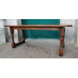 A reproduction antique style oak refectory table, the rectangular top raised on four tapered