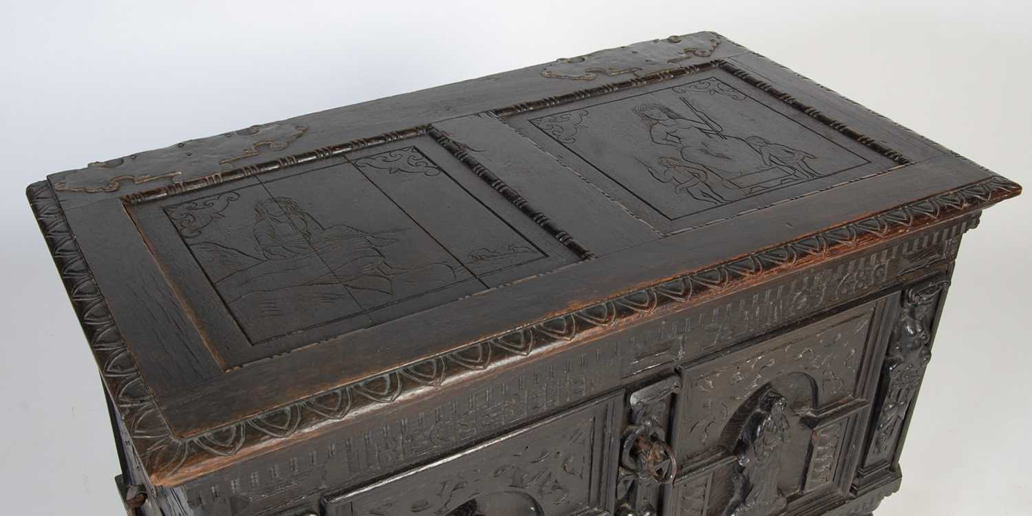 An antique stained oak coffer on integral stand, the hinged cover with two incised figural carved - Image 2 of 13