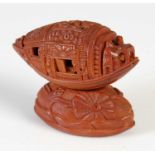 A finely carved Chinese coquilla nut, Qing Dynasty, carved as a junk on stand, the junk carved