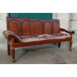 A George III oak settle, the rectangular panelled back above a later upholstered kelim covered