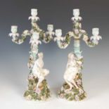A pair of Sitzendorf porcelain four-light candelabra, each modelled with a classical maiden and