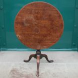 A George III mahogany snap top occasional table, the hinged circular top resting on a tapered