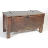 An antique oak coffer, the hinged rectangular top with double channel line border and elongated iron