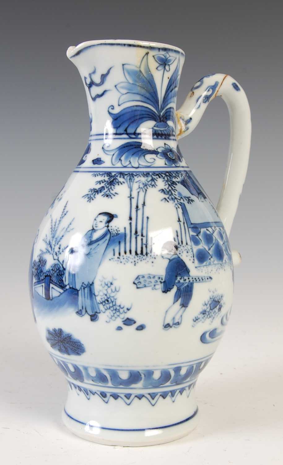 A Chinese porcelain blue and white jug, Qing Dynasty, decorated with three figures in a fenced