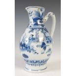 A Chinese porcelain blue and white jug, Qing Dynasty, decorated with three figures in a fenced