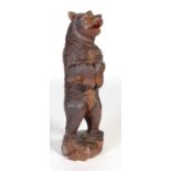 A 19th century Black Forest carved wood figure of a bear, with glass eyes and painted detail,