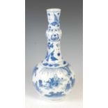 A Chinese porcelain blue and white bottle vase, Qing Dynasty, decorated with scholars and other