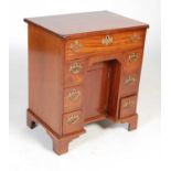 A George III style mahogany kneehole desk, the rectangular top with moulded edge and re-entrant