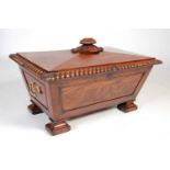 A large 19th century mahogany sarcophagus-shaped wine cooler, the hinged cover centred with oval bud