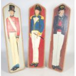 Three vintage hand painted fairground boards, decorated with military figures within rope mounted