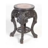 A Chinese dark wood urn stand, Qing Dynasty, the circular top with mottled purple and white marble