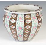 A late 19th/ early 20th century porcelain jardiniere, decorated with stylised roses and foliage on a