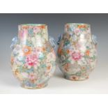 A pair of Chinese porcelain famille rose millefleur pear-shaped vases, Qing Dynasty, densely