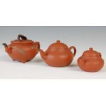 Three Chinese Yixing tea pots and covers, the largest decorated in relief with pine trees and